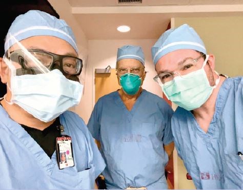 Dr. Daly (center) recently assisting in surgery with Kelvin Kwan N. Lau, MD, (left) and Dr. Farma